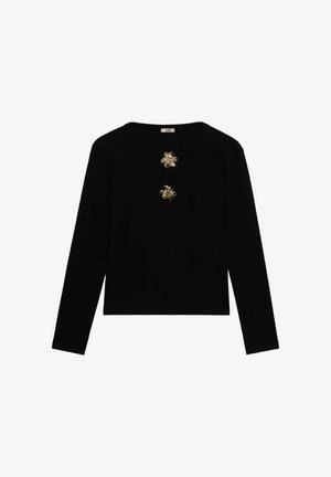 Black long-sleeve top with two decorative gold floral embellishments near the round neckline.