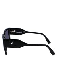 Black sunglasses with a rectangular frame. Sleek design featuring tinted lenses and textured temple accents. Branding visible on the inside.