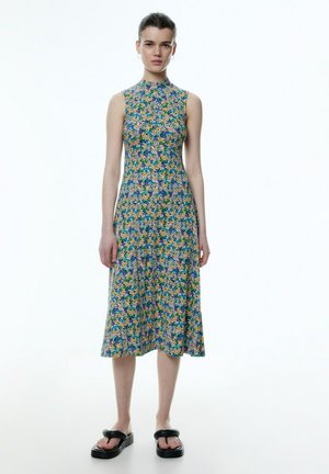 Blumenkleid mit hohem Kragen und ärmellosem Design. Es zeichnet sich durch eine Mischung aus bunten Blumenmustern auf leichtem Stoff aus und hat einen knielangen Saum.