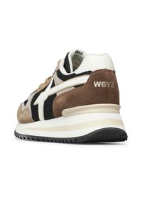 Baskets brunes et noires avec une tige en cuir et en mesh, accents blancs, semelle rembourrée, prise texturée et détail embossé "W6YZ" sur le talon.