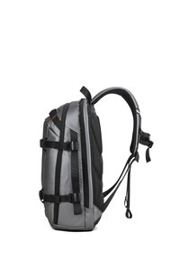 Zaino grigio e nero con spallacci imbottiti e regolabili, fibbie laterali e pannellatura testurizzata. Presenta un design elegante e strutturato.