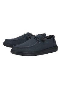 Zapatillas de lona en azul oscuro, con puntera redondeada, suela de goma negra, cierre con cordones y forro interior con estampado.