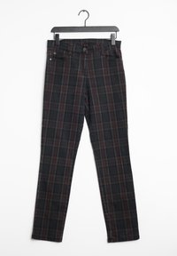 Pantalons à carreaux noirs avec un motif rouge et gris, en denim, dotés d'une fermeture à bouton et de passants de ceinture, exposés sur un cintre.
