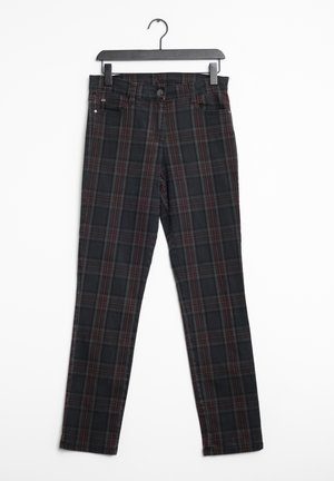 Pantalons à carreaux noirs avec un motif rouge et gris, en denim, dotés d'une fermeture à bouton et de passants de ceinture, exposés sur un cintre.