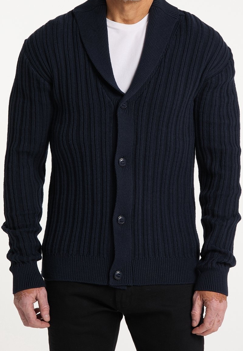 Námořnická pletená cardigan s šálovým límcem, vybavená pěti knoflíky, dlouhými rukávy a texturovaným materiálem.