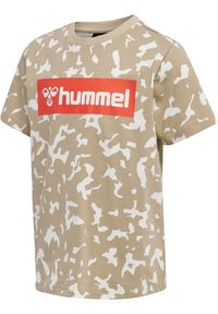 Camiseta de manga corta beige con un patrón de camuflaje en blanco. Presenta un destacado logo rectangular rojo con "hummel" en blanco en el centro.