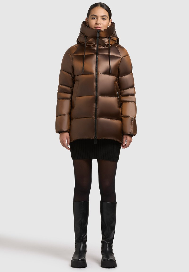Jachetă puffer cu glugă de culoare maronie, cu textură matlasată și închidere cu fermoar. Include șnururi, buzunare laterale și o croială ușor lejeră.