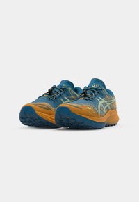 Hardloopschoenen met een blauwe mesh bovenkant en oranje accenten, een gestructureerde zool voor grip en zwarte veters. Lichtgewicht ontwerp voor optimale prestaties.