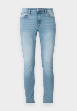 Jeans ajustados de mezclilla azul claro, con una cintura de altura media, cinco bolsillos y un ligero desvanecimiento en los muslos. Cierre de botón en la cintura.
