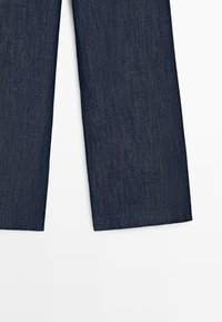 Dunkelblaue Jeansbeinlängen, gezeigt vom mittleren Oberschenkel bis zum Saum mit geradem Schnitt auf weißem Hintergrund.
