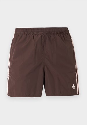 Brown athletic shorts with elastic waistband, light pink side stripes, and a small Adidas trefoil logo on the lower left leg.