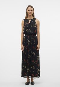 Abito maxi floreale nero con design senza maniche, caratterizzato da una scollatura a chiave e una vita elastica. Decorato con motivi floreali rossi e crema.