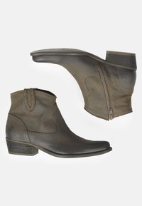 Botas de cuero marrón hasta el tobillo con puntera puntiaguda, cremallera lateral, tacón en bloque y acentos de costura decorativa. Textura ligeramente usada.