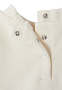 Nahaufnahme eines cremefarbenen Strickstoffs mit geripptem Kragen und drei Metall Druckknöpfen, von denen ein Knopf teilweise geöffnet ist.