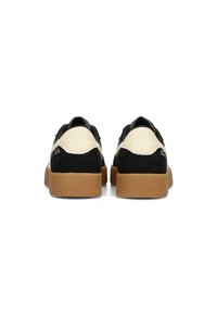 Schwarz-weiße Schuhe mit einem Obermaterial aus Wildleder, strukturierten Details und Gummisohlen. Entworfen mit einem niedrigen Profil und einem runden Absatz.
