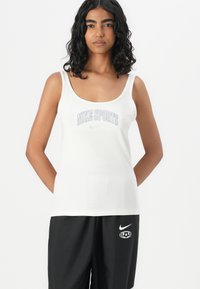 Hvit atletisk tanktopp med rund hals, med teksten "NIKE SPORTS" i lysegrå over brystet. Myk, tettsittende tekstur.