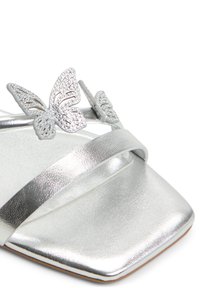 Silver metallic sandal featuring a square toe, thin straps, and embellishments of two butterfly motifs with shimmering details.
