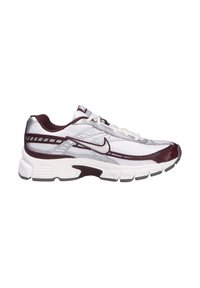 Zapatilla deportiva de Nike con parte superior de malla blanca, acentos en color burdeos, detalles plateados y una suela blanca acolchada con banda de rodadura gris texturizada.