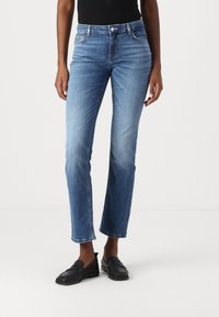 Jeans in denim blu chiaro con un design slim e gamba dritta, caratterizzati da cinque tasche e vita a media altezza.