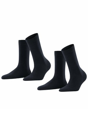 Set di quattro calzini neri in cotone. Le caratteristiche includono una texture liscia, una parte superiore a coste, tallone e punte rinforzati. Lunghezze classiche alla caviglia e in crew.