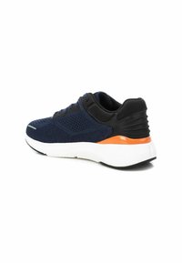 Zapatilla deportiva azul marino con parte superior de malla texturizada, soporte de talón negro, acento naranja y suela acolchada blanca.