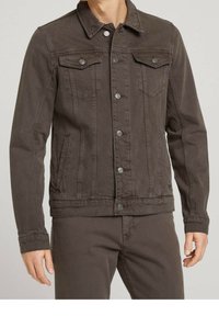 Veste en denim marron avec un col classique, fermeture à boutons sur le devant, deux poches poitrine et poches latérales. Présente une finition texturée et une coupe ajustée.