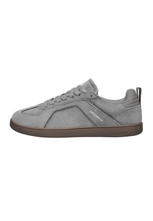 Szary zamszowy sneaker z sznurowadłami, brązową podeszwą, wyściełanym kołnierzem, pętelką na pięcie oraz logo "Giesswein" po boku i na podeszwie.