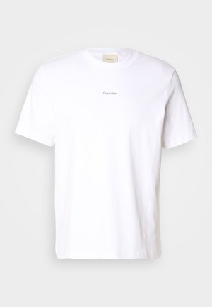 Hvit bomulls t-skjorte med korte ermer, rund hals og en liten svart "Calvin Klein"-logo trykket på forsiden.