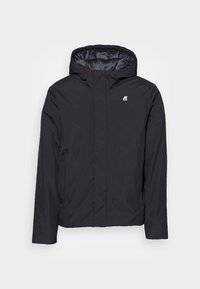 Černá mikina s kapucí s hladkou texturou, s malým logem na hrudi a jednoduchým předním designem. Lehký a ležérní styl.