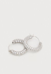 Pendientes de aro plateados con un diseño curvo. Decorados con varios cristales transparentes a lo largo del borde exterior, creando un acabado texturizado.