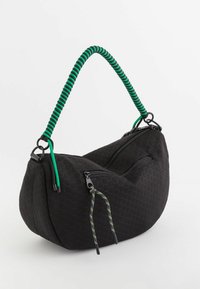 Czarna torebka o heksagonalnej strukturze i zaokrąglonym kształcie, z zielonym spiralnym uchwytem, dwoma zamykanymi na zamek komorami i kolorowymi detalami akcentującymi.