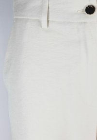 Pantaloni bianchi in misto cotone con una superficie liscia, dotati di chiusura con bottone frontale, passanti per cintura e tasche laterali. Design minimalista.