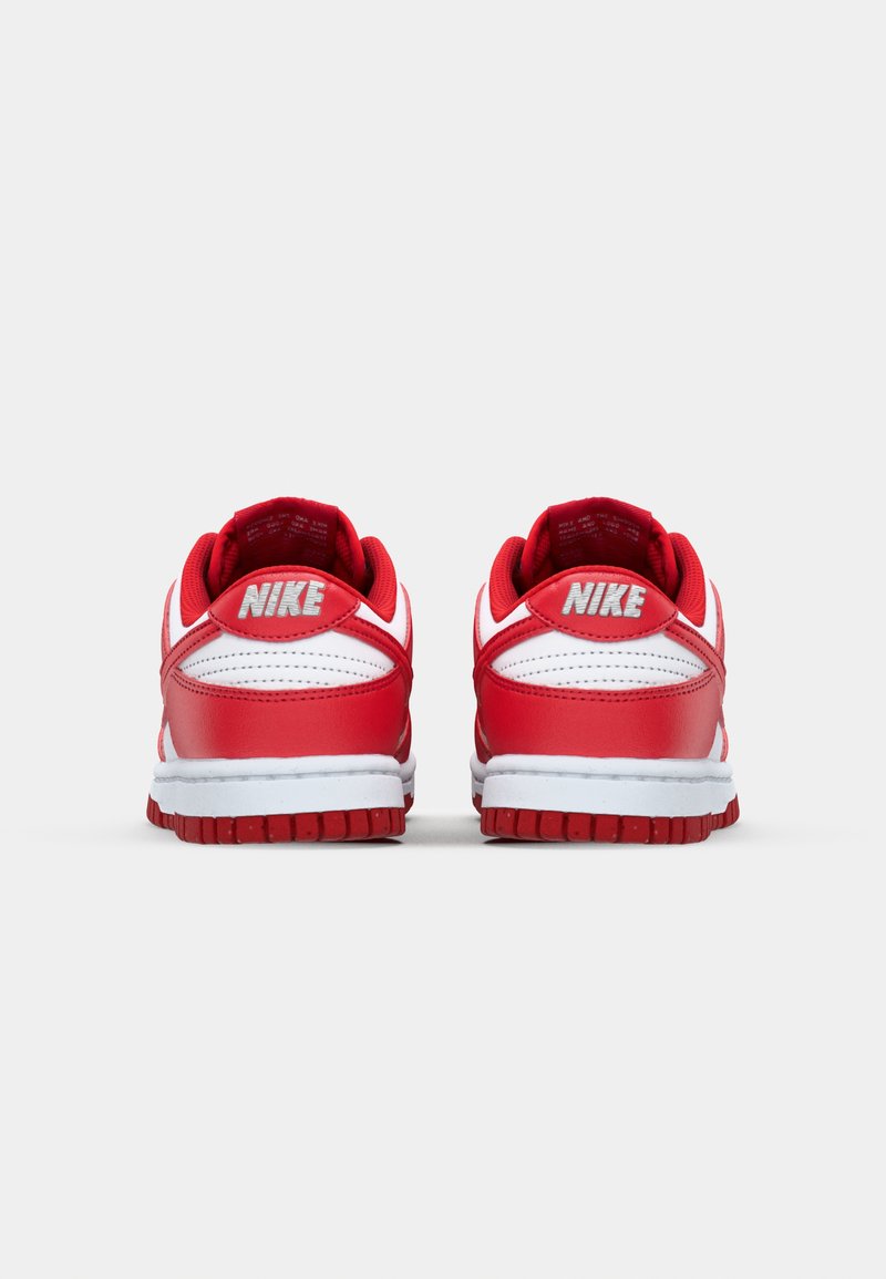 Baskets Nike avec un dessus en cuir rouge, des accents blancs, un col rembourré et une semelle en caoutchouc texturé. L'arrière affiche le logo Nike.