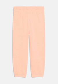 Peachfargede leggings laget av myk stoff, med elastisk midje og rynkete ankelmansjetter for en tett passform.