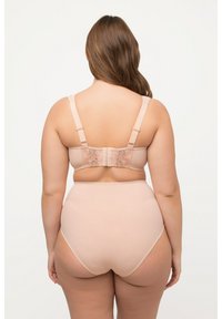 Soutien-gorge nude avec des détails en dentelle au dos, bretelles ajustables et texture lisse. Culotte taille haute nude complète l'ensemble.