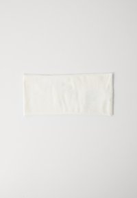 Panno bianco rettangolare piegato, disteso su una superficie bianca con cuciture visibili su un lato.