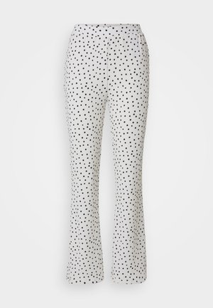 Pantaloni bianchi con pois neri, caratterizzati da un design svasato e una vita elastica. Realizzati in tessuto leggero e testurizzato.