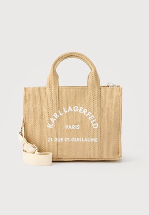 Bež pletena torba za nošenje z kratkimi ročaji in odstranljivim naramnim trakom, z belo napisom "Karl Lagerfeld Paris 21 Rue St-Guillaume".