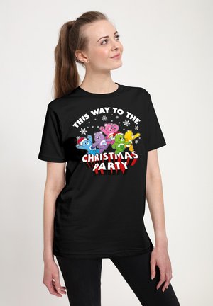 Sorte T-shirt med farverige tegneserie-bjørne, teksten siger "DENNE VEJ TIL JULEFESTEN," med snefnug og et festligt design.