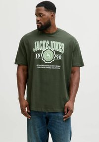 Zielona bawełniana koszulka z krótkim rękawem, z białym nadrukiem graficznym z napisem "JACK&JONES" oraz rokiem założenia. Okrągły dekolt, luźny krój.