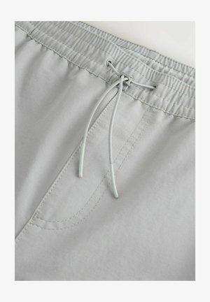 Világosszürke, rugalmas derékpánttal ellátott rövidnadrág, húzózsinórral és elöl varrott zsebbekkel. Puha szövettextúra.