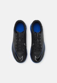 Schwarze Sportschuhe mit einer strukturierten Oberseite, die blaue Akzente, eine blaue Innensohle und einen weißen Swoosh aufweisen. Die Schnürsenkel verlaufen durch sechs Ösen.