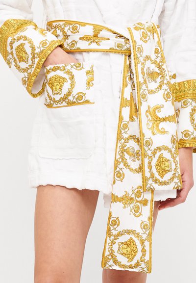 Weißer Morgenmantel mit goldenen Akzenten und einem Gürtel. Das Design umfasst kunstvolle Motive an den Manschetten und Taschen, die ein luxuriöses Erscheinungsbild zeigen.