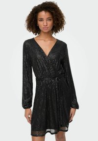 Crna haljina od sequina, omotana, s dugim rukavima, V-izrezom, detaljem vezanja u struku i lepršavom suknjom, s sjajnom teksturiranom površinom.