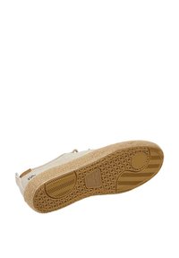 Sole di espadrille color beige chiaro con una base in gomma testurizzata, parte superiore in tessuto intrecciato e cuciture decorative lungo i lati.