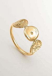 Anillo de oro con tres acentos circulares texturizados, uno de ellos con una gema central, que exhibe detalles pulidos y embossados en cada elemento.
