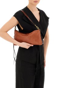 Borsa a tracolla in pelle marrone con una superficie liscia, forma slanciata e sottile, e tracolla staccabile. Presenta dettagli intrecciati su un lato.