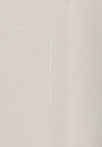 Helle beigefarbene Stoff mit strukturiertem Strick und einem vertikalen, in Weiß gedruckten Logo "FRENCH CONNECTION" an der Seite.