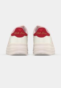 Paire de baskets compensées blanches avec semelles rose clair et languettes de talon rouges brodées de "With Love" et de symboles de cœur.