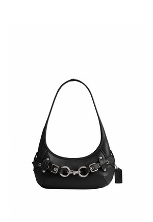 Sac à épaule en cuir noir avec boucle argentée et détails en anneau, ainsi qu'une petite étiquette suspendue sur fond blanc.